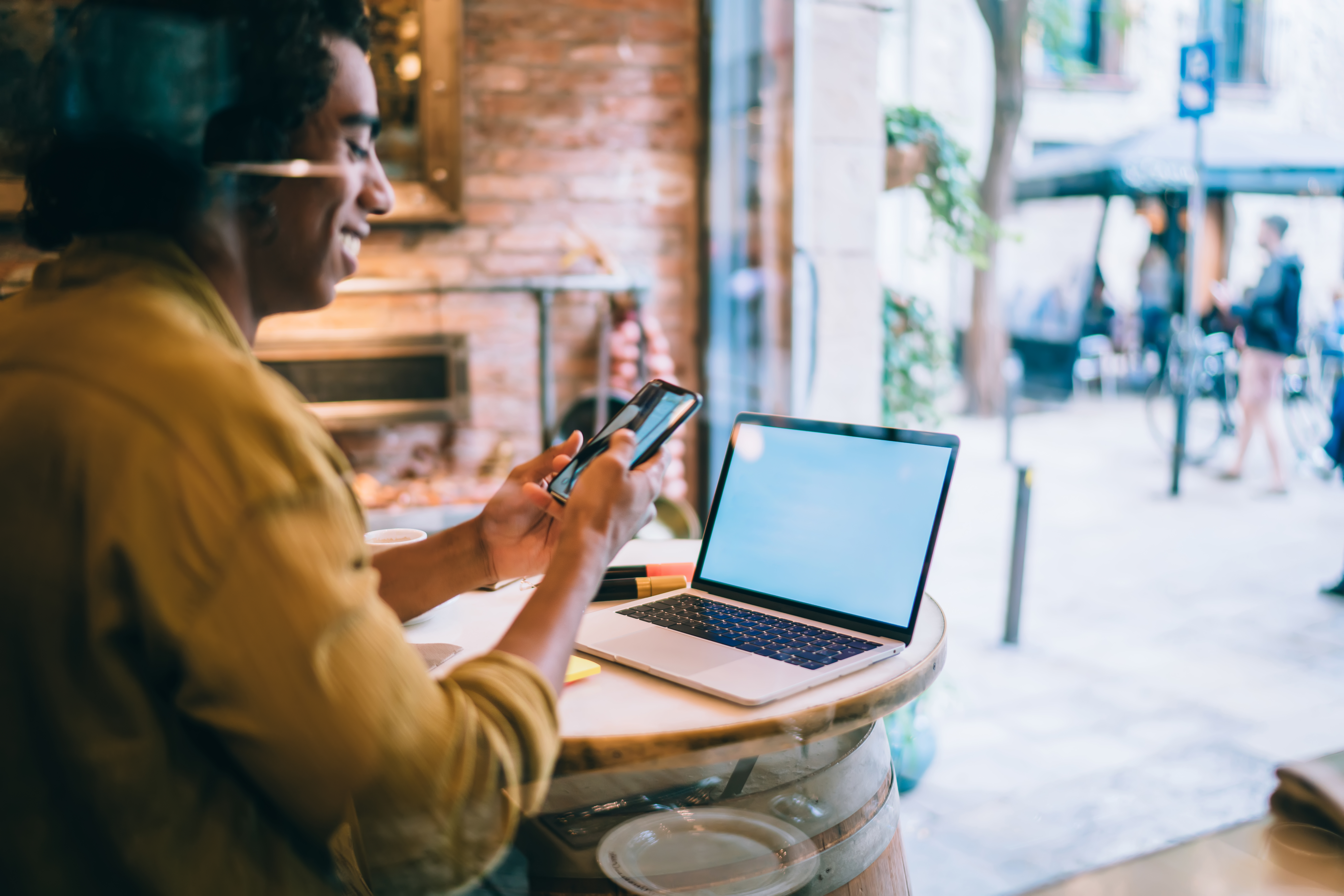 Smiling businessman browsing smartphone while sitting in cafe with laptop smiling businessman browsing smartphone while sitt 2025 03 27 02 23 30 utc